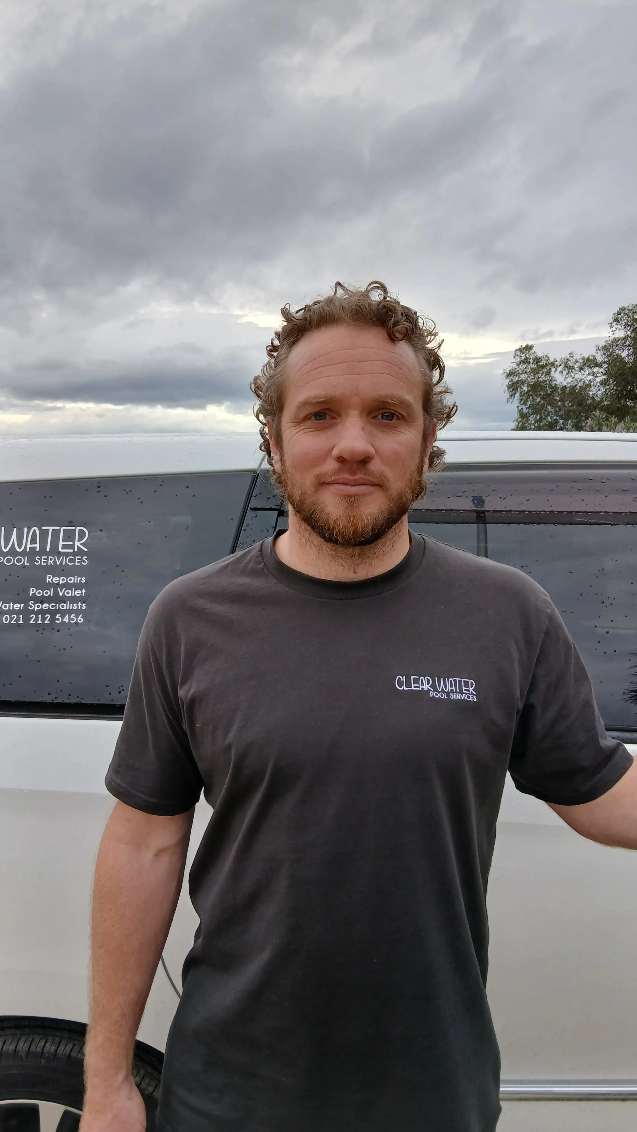 Caleb Heath standing in front of the Clear Water van.